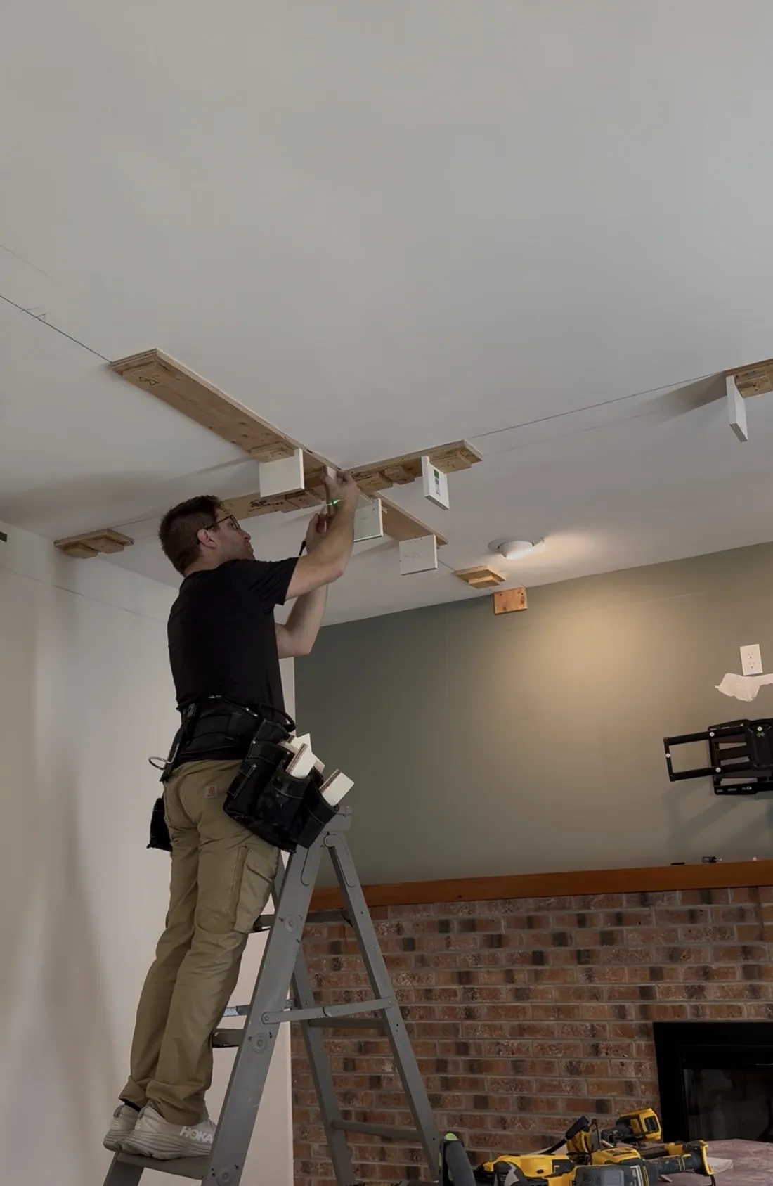 Ceiling mounting blocks marked, cut, and installed to a laser line to establish a level plane for coffered beam bottoms