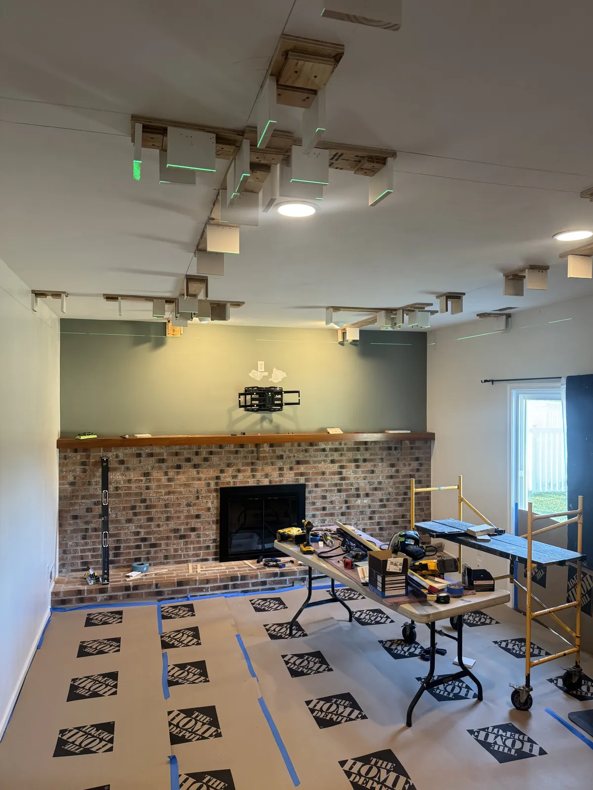 Coffered ceiling in progress with mounting blocks hung to a laser-leveled plane before finished beams are installed